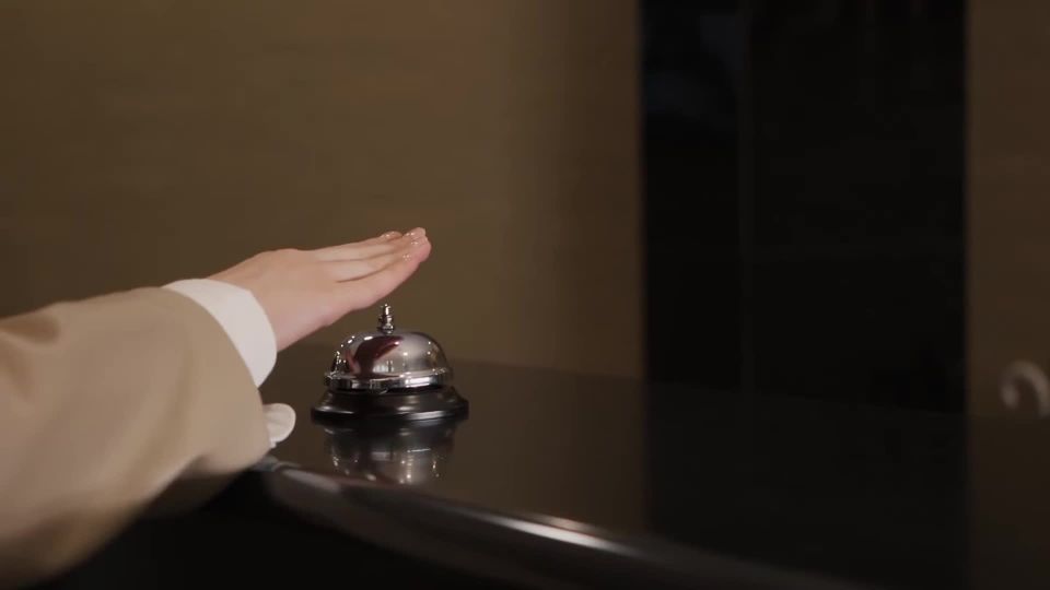 A hand ringing a hotel reception bell